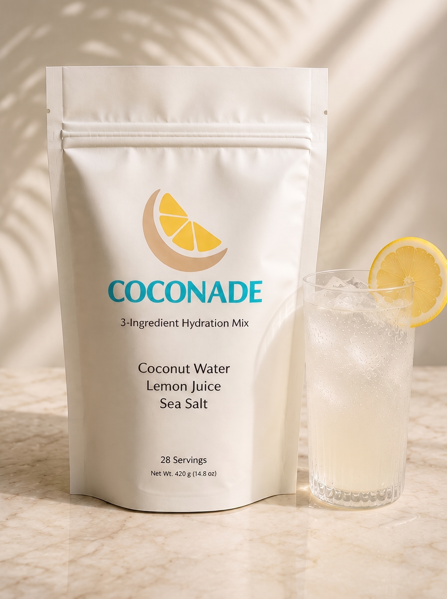 Coconade 28-serving pouch of 3-ingredient hydration mix beside a glass of iced coconut lemonade